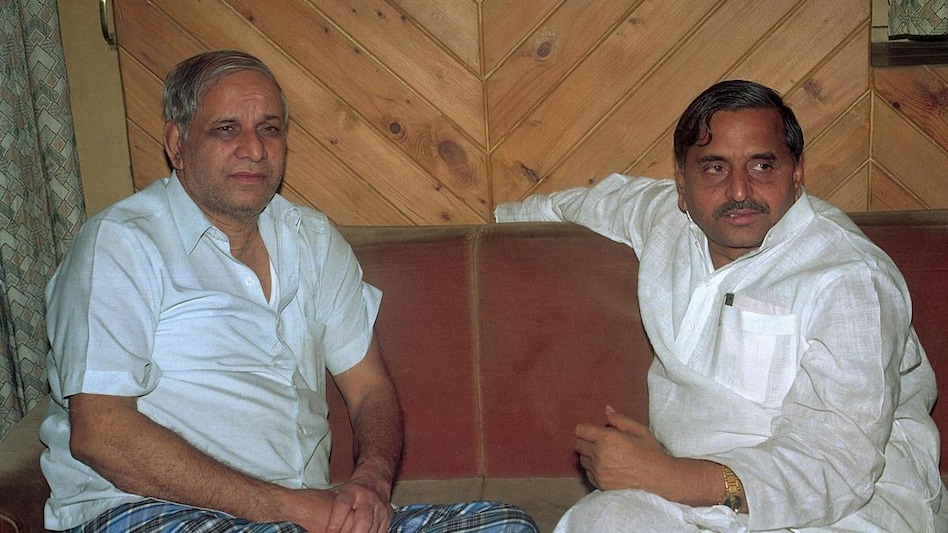 कांशीराम और मुलायम सिंह यादव सामाजिक न्याय की दो राहें एक मंजिल दर्शाती हुई यथार्थवादी तस्वीर, जिसमें दोनों नेता साथ चलते हुए दिख रहे हैं और पृष्ठभूमि में सामाजिक संघर्ष और एकजुटता का दृश्य दिखाई दे रहा है।